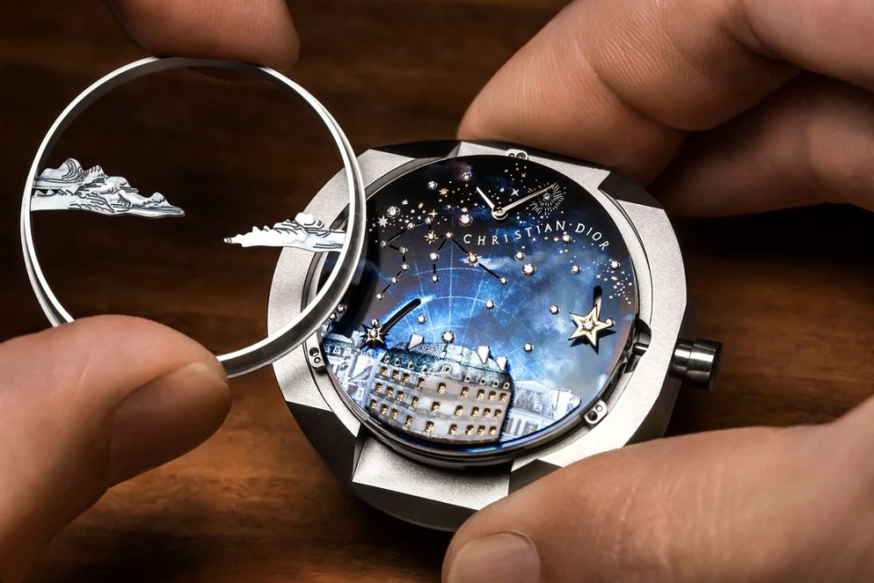 Close-up of hands holding a luxury wristwatch with a detailed celestial scene dial, crafted by Christian Dior, showing intricate artistic elements.