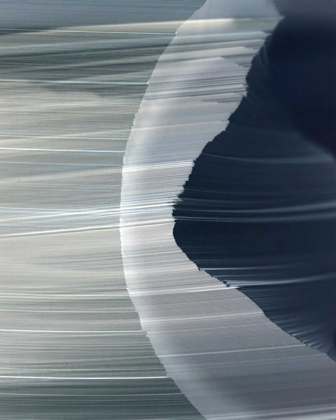 Abstract painting with flowing lines and curves in shades of gray and navy blue, creating a sense of movement and depth.