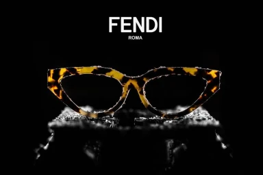 Tortoiseshell cat-eye glasses resting on a textured surface under dramatic lighting with Fendi logo above