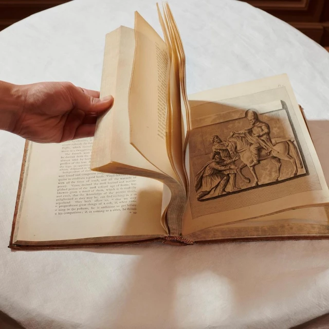 Open antique book showing text on one page and an illustration of a man on horseback on the opposite page being held.