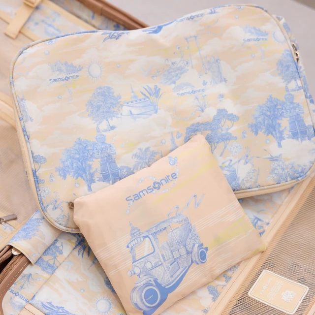 Open suitcase with patterned packing cube and bag featuring a blue tuk-tuk design, ideal for travel-themed visuals.