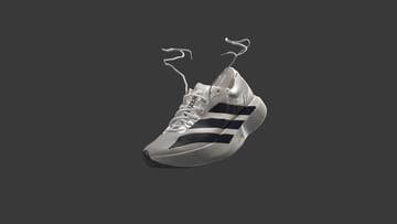 Single white Adidas running shoe floats against a dark gray background in a studio product shot with the shoelaces hanging down.