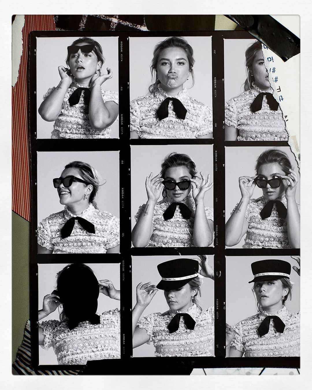 Black and white photo booth style portrait of a woman wearing sunglasses and a dress with a bow tie, surrounded by torn paper.