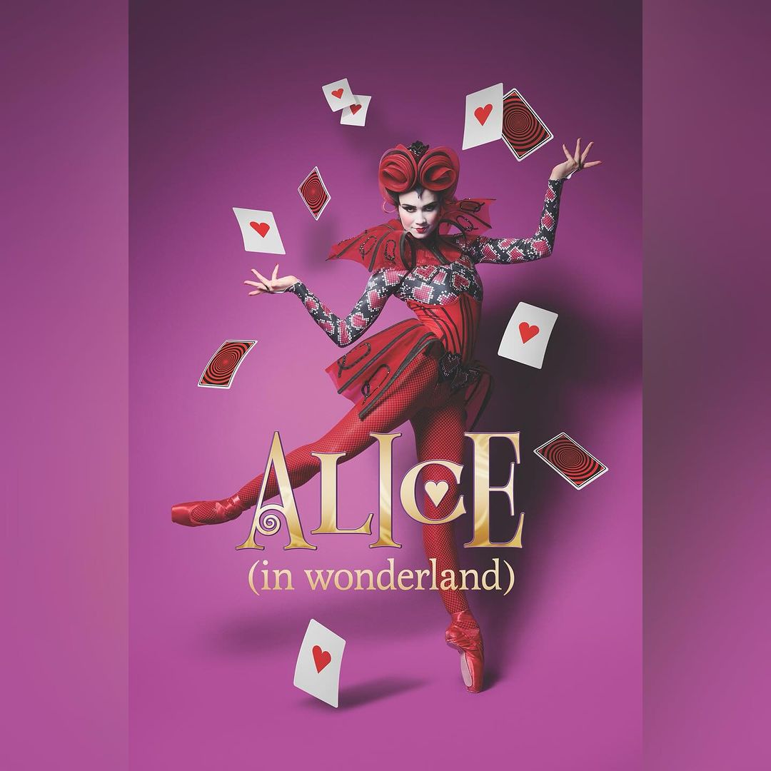 A costumed woman in a fantasy portrait for 'Alice in Wonderland' stands on pointe, juggling playing cards, against a purple backdrop.