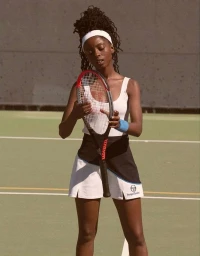 Black female tennis player holding a racket on a tennis court, wearing a white tank top and skirt.