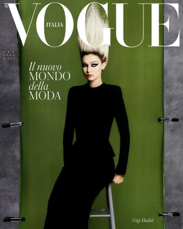 Vogue Italia magazine cover featuring model Gigi Hadid in a black dress with dramatic hairstyle, set against a green backdrop with styling clamps.