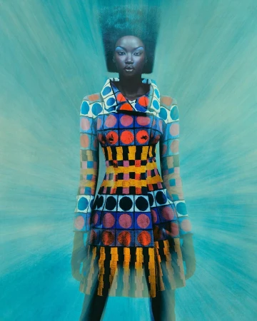 Black woman wearing a brightly patterned geometric coat and blue eye makeup against a teal textured background.