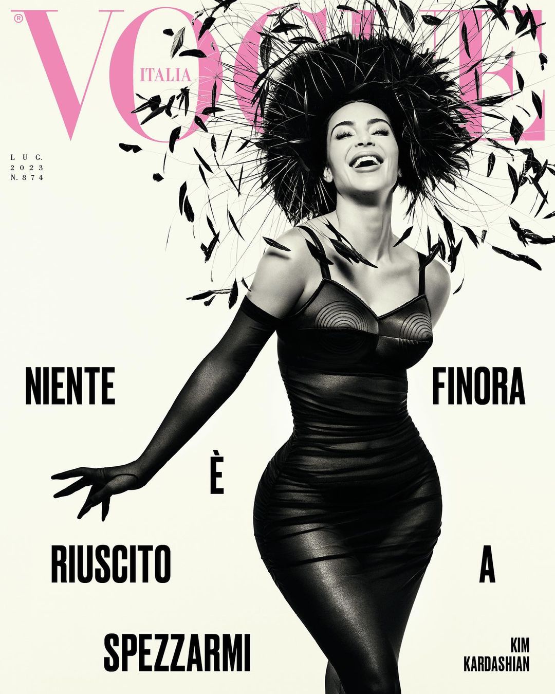 Vogue Italia cover featuring Kim Kardashian wearing a black dress and a feathered headpiece, smiling against a cream background with magazine text.