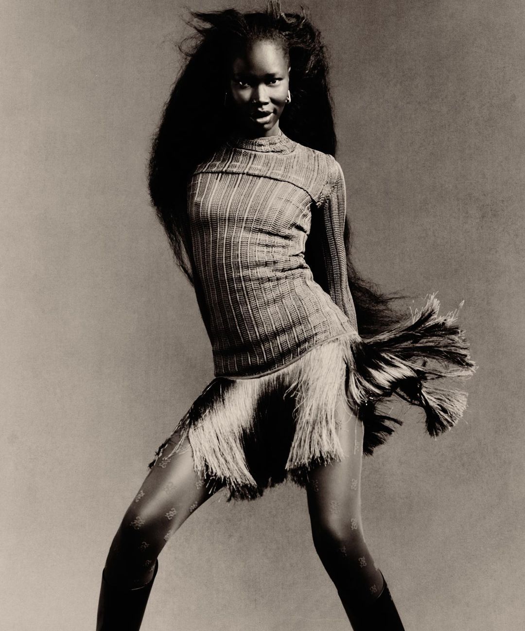 Black woman with long voluminous dark hair wearing a ribbed top and fringed skirt by photographer Rafael Pavarotti.