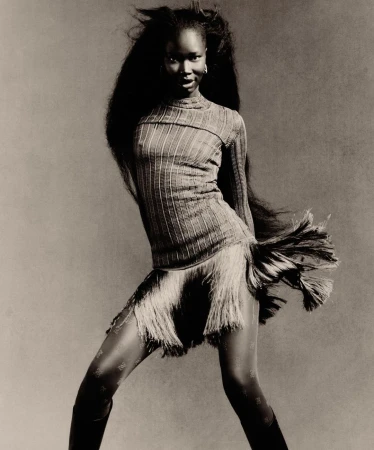 Black woman with long voluminous dark hair wearing a ribbed top and fringed skirt by photographer Rafael Pavarotti.