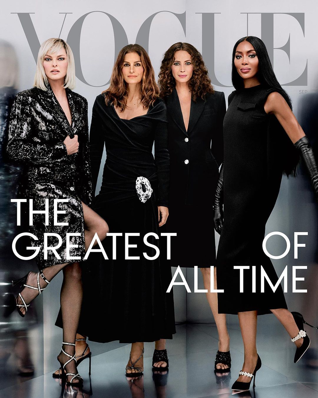 Vogue magazine cover features four women in black dresses and heels posing in front of a blurry background with “The Greatest of All Time” text.