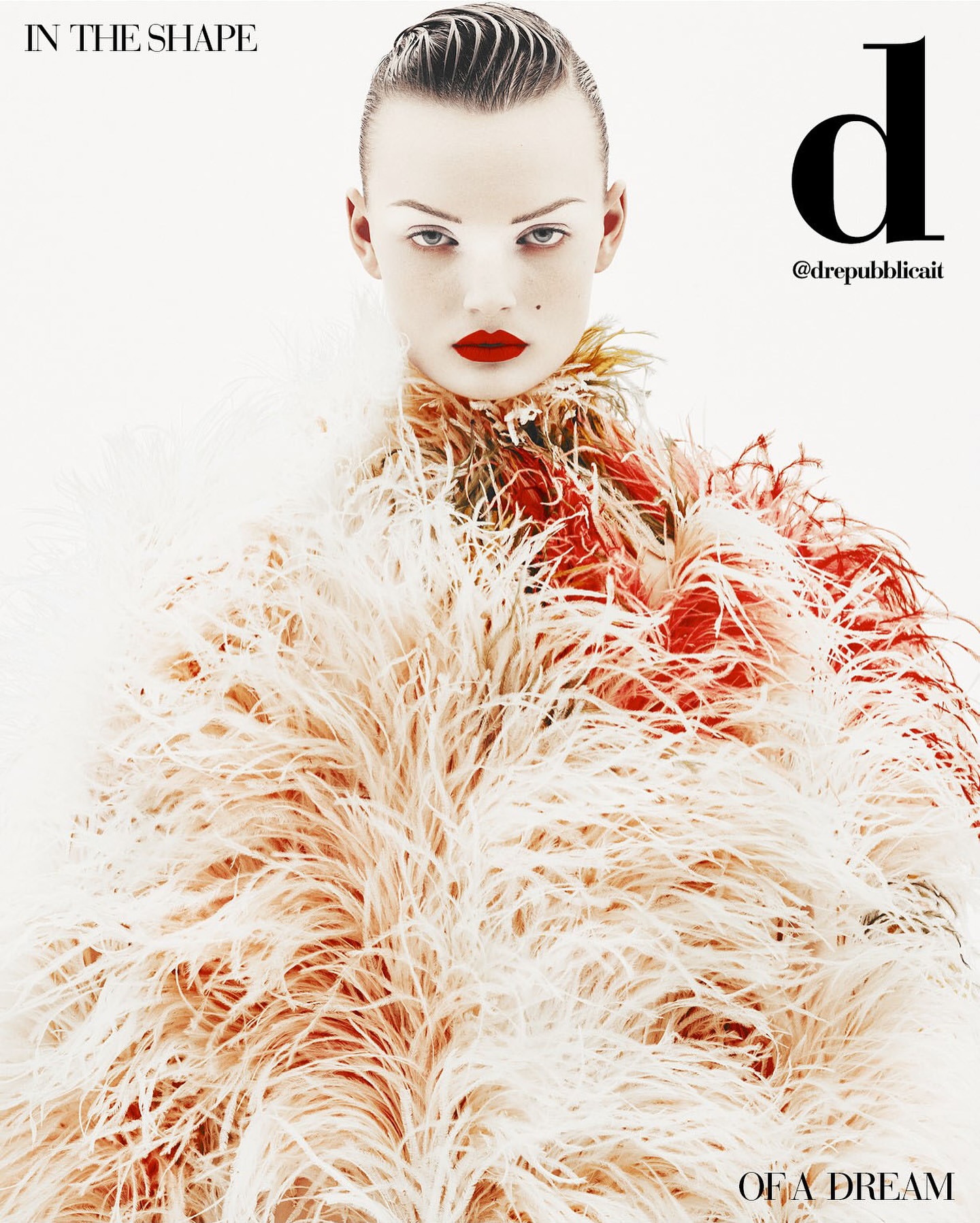 Close-up shot of a model with slicked-back hair and red lipstick wearing a feathered garment against a bright white backdrop.