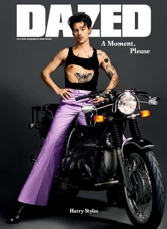 Harry Styles on a motorcycle for Dazed magazine, wearing a black tank top, lavender pants, with Dazed logo and 'A Moment, Please' text.