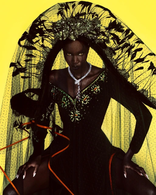 Dramatic fashion shot of a dark-skinned model in a black dress, large crown, and veil against a bright yellow backdrop.