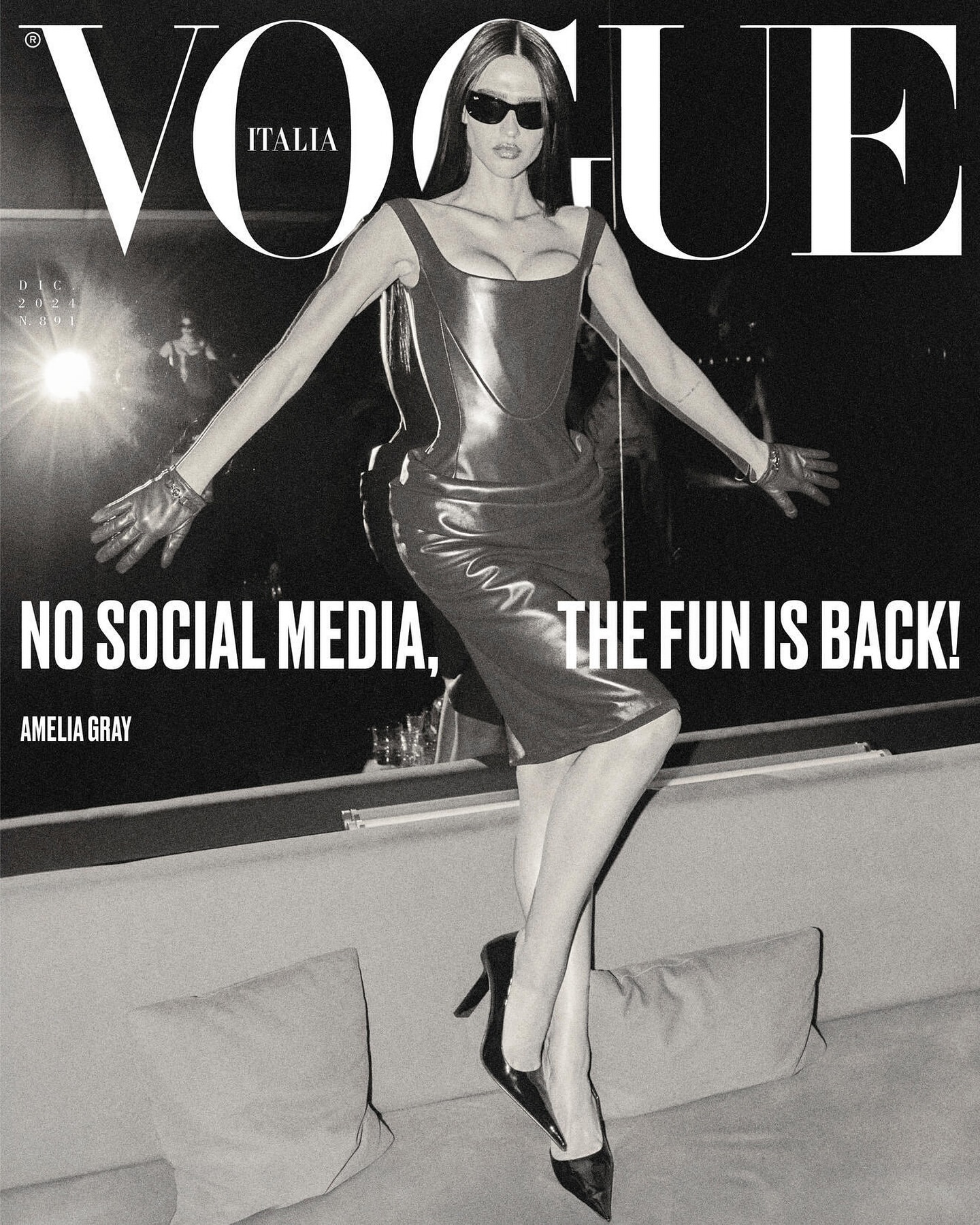 Vogue Italia magazine cover featuring Amelia Gray in a black dress and gloves, striking a pose on a textured couch.