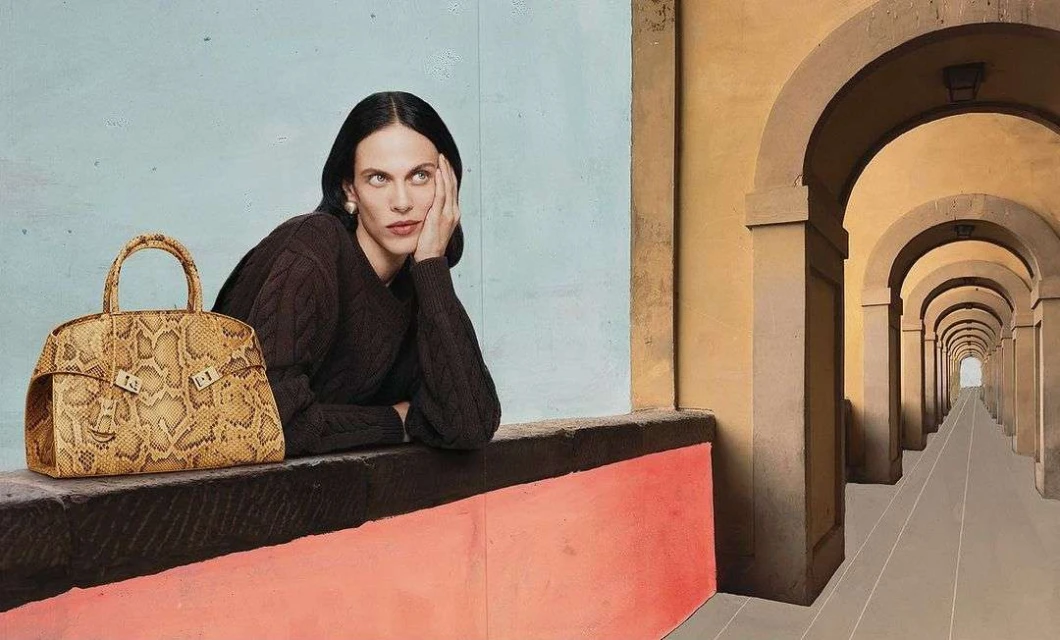 Woman poses with a snakeskin purse in front of an archway. The background is blue and pink, and the foreground is yellow and brown.