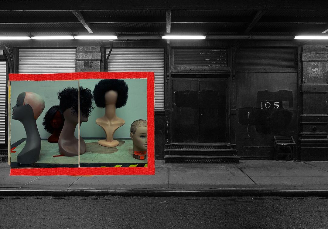 Storefront window display featuring mannequin heads with wigs in an urban setting, grayscale building exterior with the number 105.