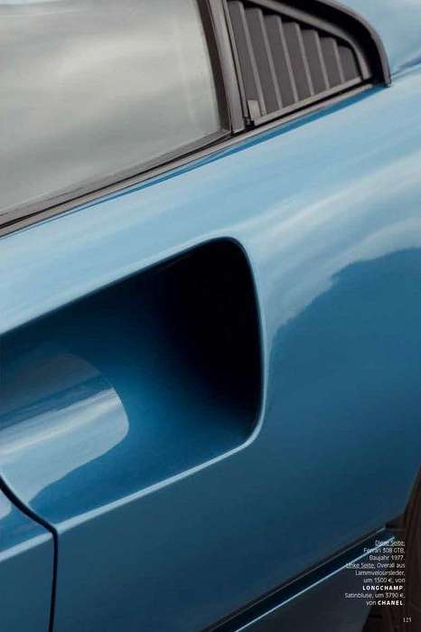 Close-up of the side of a light blue vintage car with black window trim and vent, capturing the vehicle's design and color.