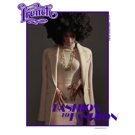 Model with large afro hairstyle wearing cream turtleneck knitwear, skirt, and coat, photographed by Ralph Mecke