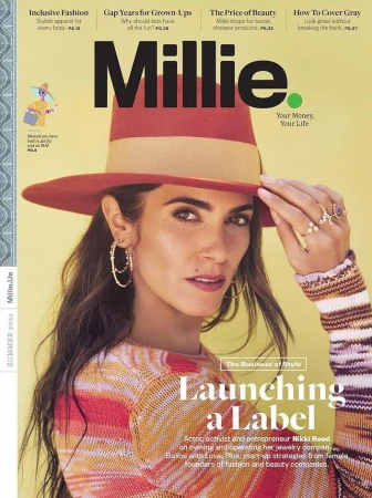 Close-up magazine cover portrait of Nikki Reed wearing a red fedora and striped knit sweater against a yellow background.