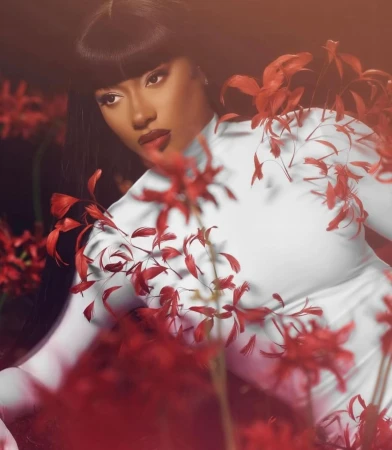 Megan Thee Stallion wearing a white high-neck top surrounded by vibrant red flowers captured by photographer Ramona Rosales