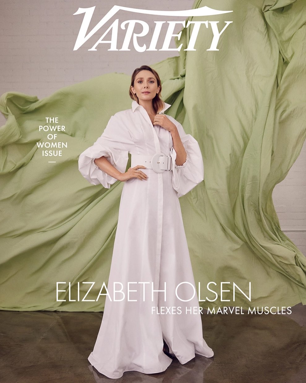 Elizabeth Olsen on a Variety cover, posing in a white belted dress with puffy sleeves against a light green draped fabric backdrop.
