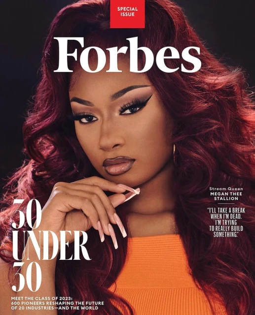 Forbes magazine cover featuring Megan Thee Stallion, wearing an orange top, long nails and wavy red hair, against a black background.