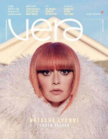 Magazine cover featuring Natasha Lyonne with an orange bob haircut, wearing a white faux fur coat, with architectural elements in the background.