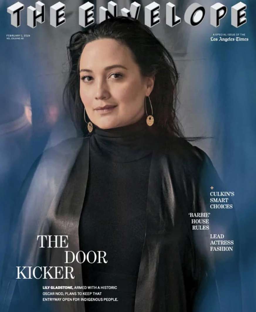Lily Gladstone on 'The Envelope' cover, Los Angeles Times special edition, featuring black top and long gold earrings in portrait shot.