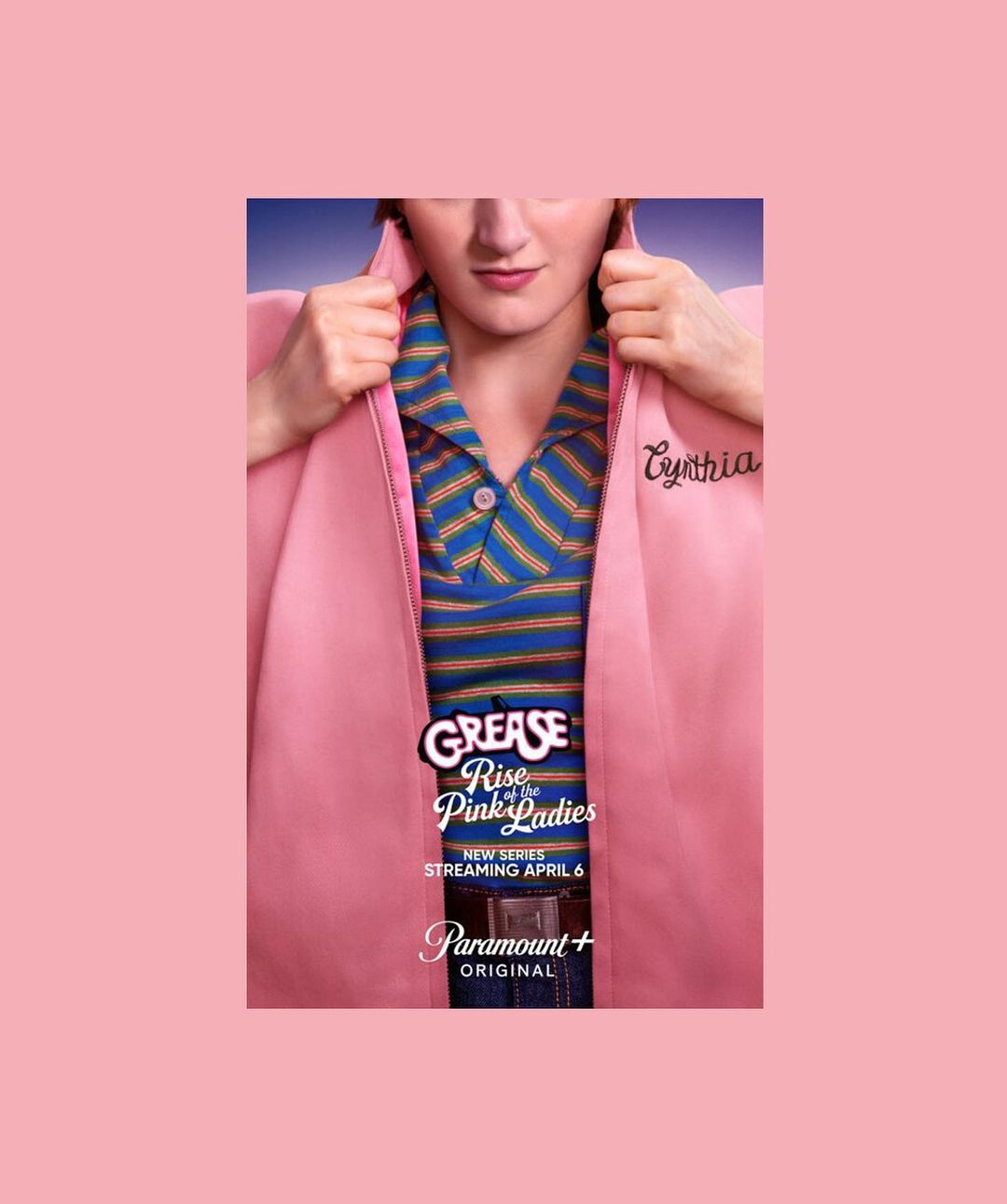 Promotional image for 'Grease: Rise of the Pink Ladies' featuring actor in Pink Ladies jacket, striped shirt, and belt buckle.