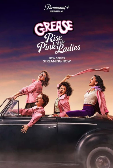 Four women in 1950s attire ride in a classic car against a twilight sky for 'Grease: Rise of the Pink Ladies' Paramount+ series promo.