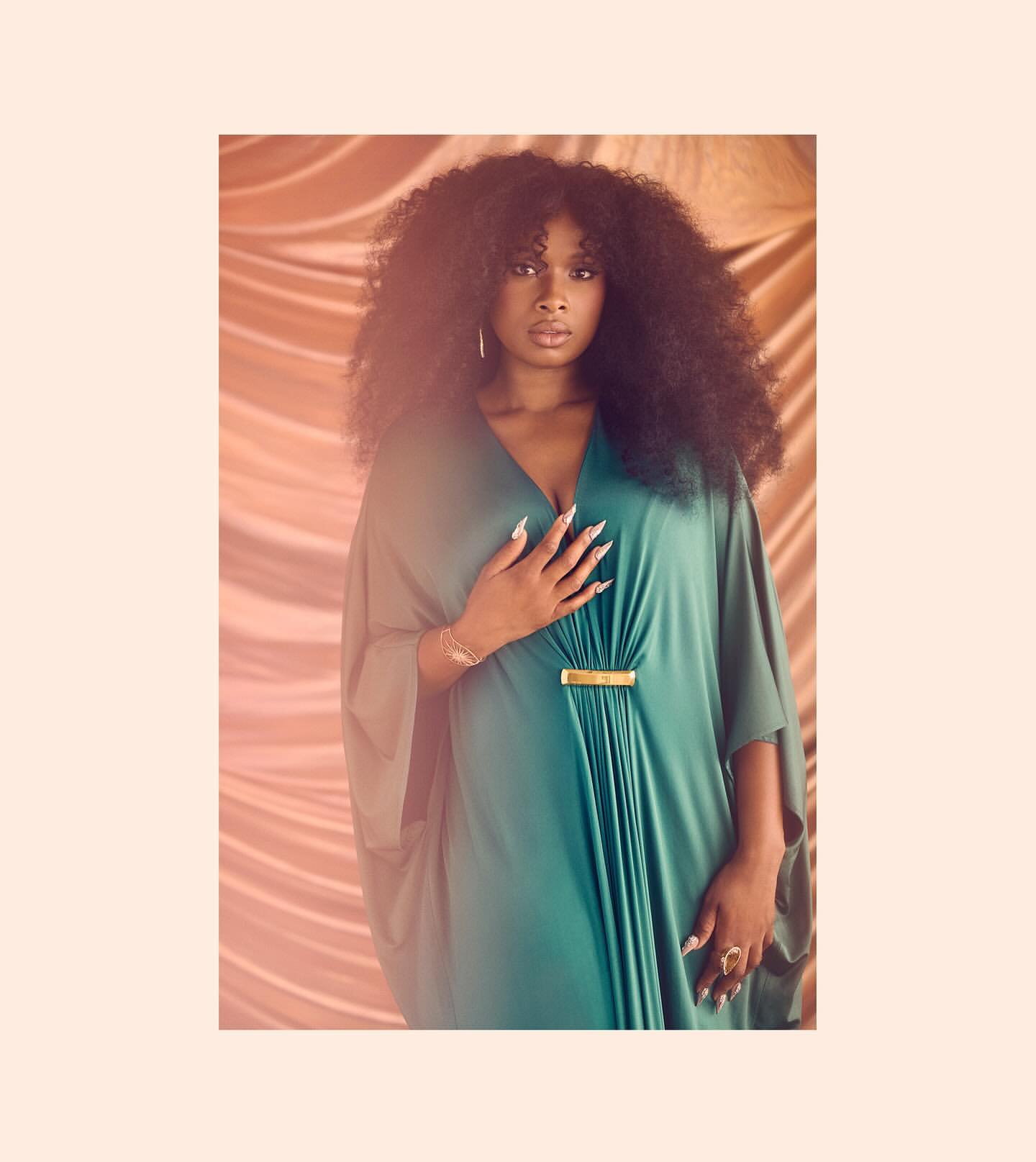 Portrait of Jennifer Hudson in a flowing green caftan standing against a draped satin backdrop by Ramona Rosales