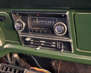 Vintage Philco car radio and climate control panel set into a green dashboard.