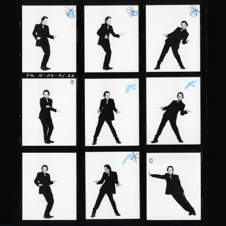 Black and white contact sheet features a man in a suit striking various poses against a plain white background, captured across nine frames.