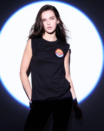 Woman in black sleeveless t-shirt standing in front of a circular blue projection light