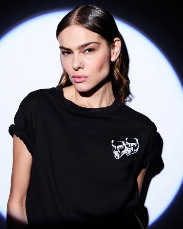 Portrait of a woman wearing a black t-shirt under a spotlight, photographed by Rankin in New York.