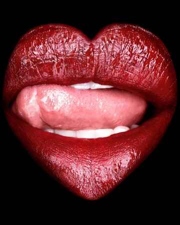Close-up studio shot of a person's mouth with red lipstick formed like a heart shape, slightly open with the tongue visible against a black background.
