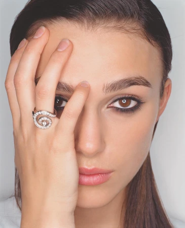 Close-up portrait of a woman holding her hand to her face, showcasing a diamond spiral ring against a plain white background.