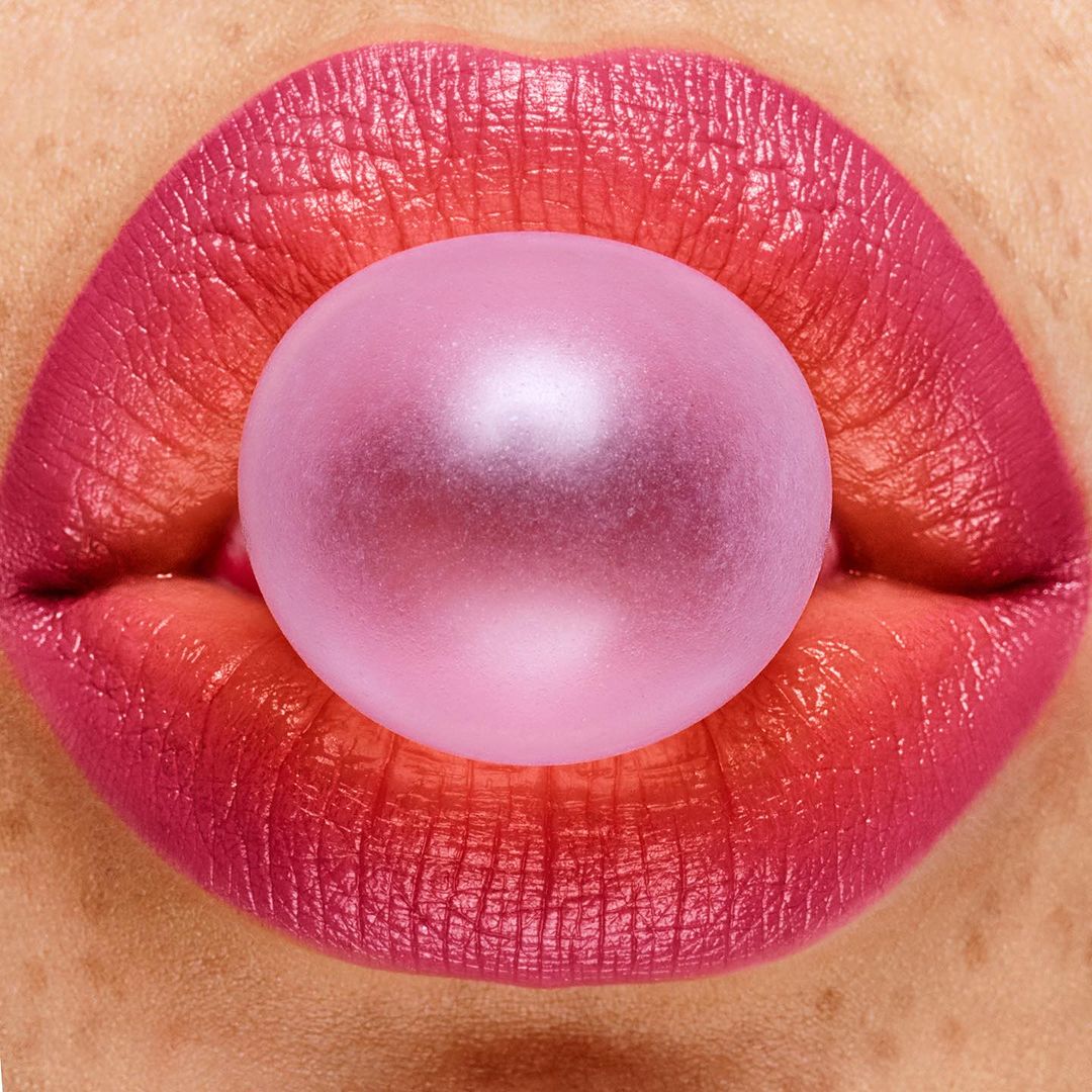 Macro shot of pink lips with a bubblegum bubble, creating a vibrant and playful close-up image focused on beauty and texture.