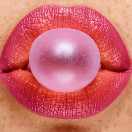 Macro shot of pink lips with a bubblegum bubble, creating a vibrant and playful close-up image focused on beauty and texture.