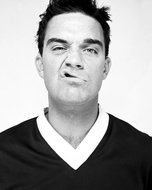 A black and white portrait of a man with a funny expression. He's wearing a dark shirt, and the shot is a close-up.