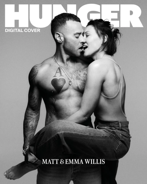 Black and white magazine cover featuring a shirtless man with tattoos holding a woman in his arms, both with mouths open.