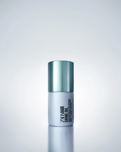 Zara Hair Shine Oil product shot with teal and white container against a gradient background. Cosmetic product photography.