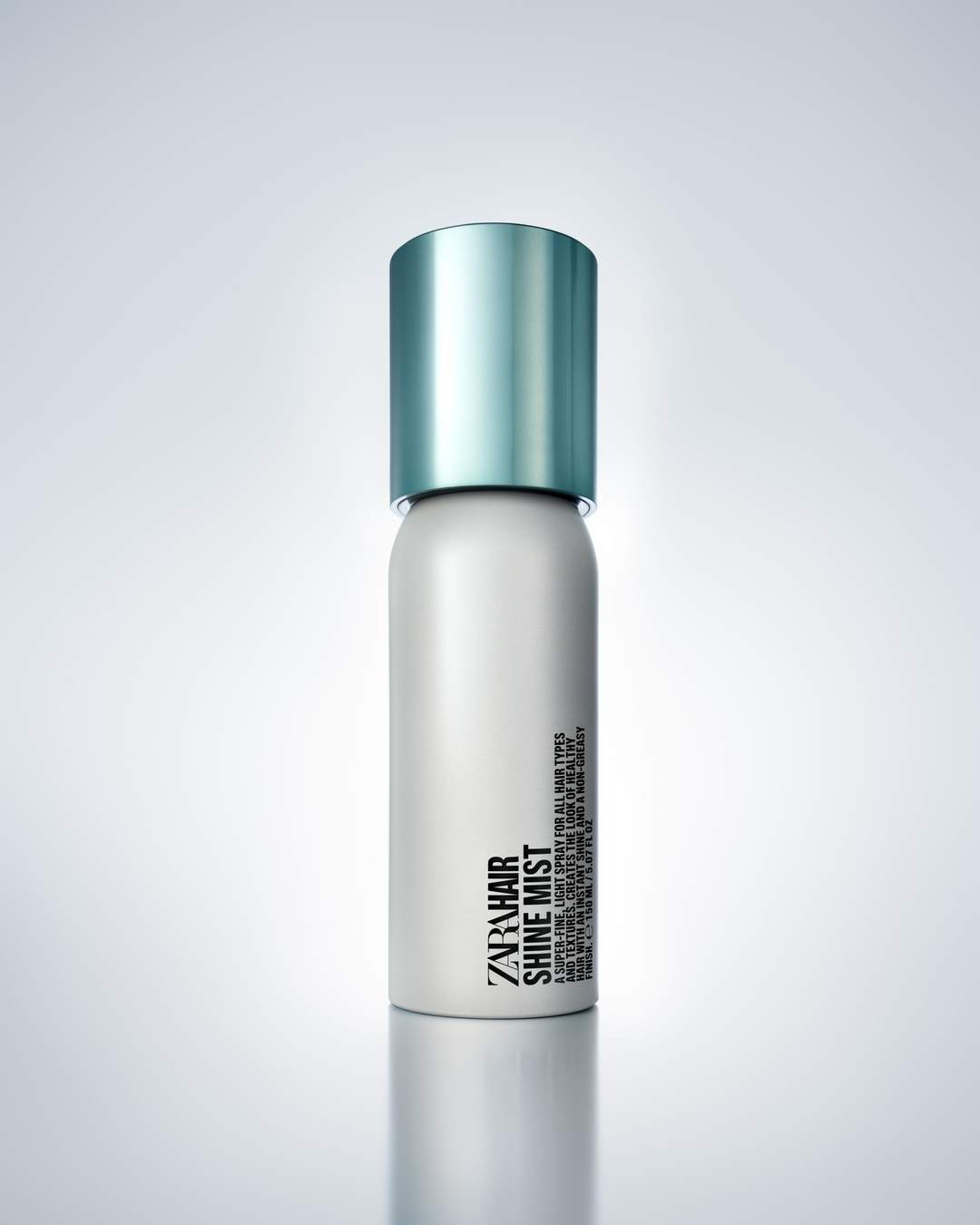 A single can of Zara Hair Shine Mist sits on a white surface with soft studio lighting and a subtle gradient background.