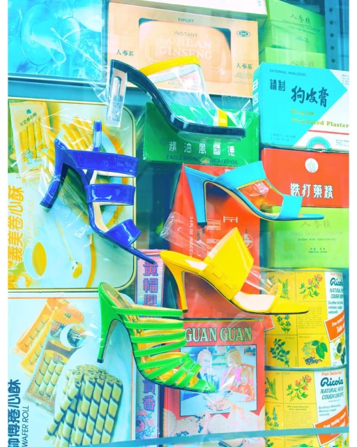 Colorful heeled sandals displayed against vintage packaging. High heels in blue, green, yellow, and black and white colors fill the frame.