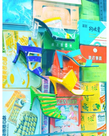 Colorful heeled sandals displayed against vintage packaging. High heels in blue, green, yellow, and black and white colors fill the frame.
