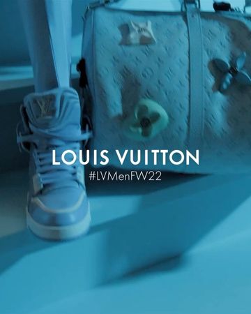 Light blue Louis Vuitton high-top sneaker next to a matching monogrammed bag, on a light blue surface with a visible brand logo.