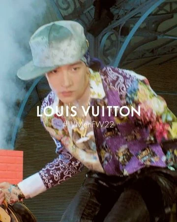Man in a floral-patterned button-down and baseball cap with Louis Vuitton text overlay for a fashion advertisement.