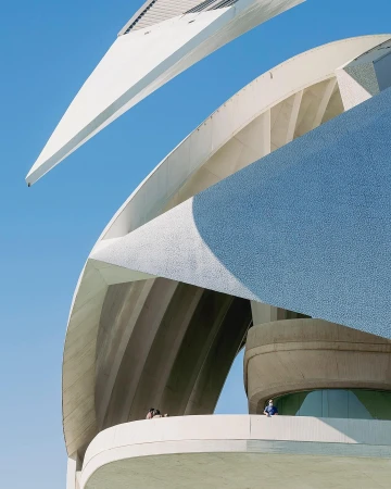 City of Arts and Sciences in Valencia, Spain, featuring modern architecture, patterned facades, and clear blue sky, viewed from a low angle.