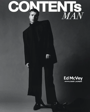 Black and white magazine cover featuring a young man in a black suit. The cover includes the magazine's title and the model's name.